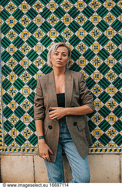 Blonde Frau posiert gegen eine geflieste portugiesische Wand