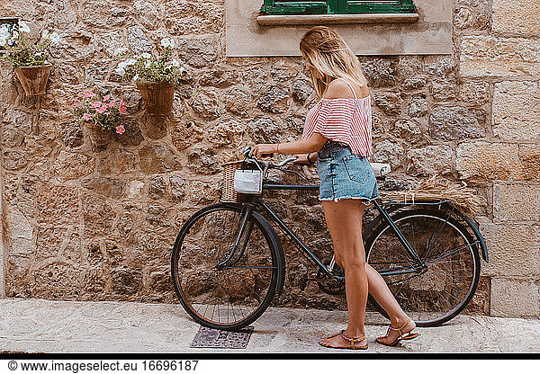 blonde Frau wählt das Fahrrad als Transportmittel auf Mallorca