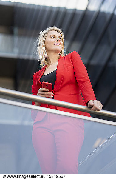 Blonde Geschäftsfrau im roten Anzug