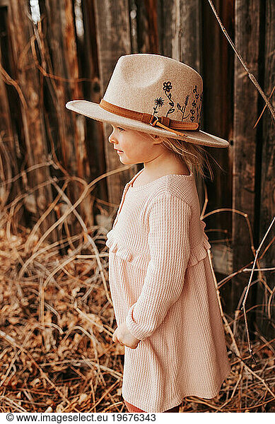 Blonde girl in floral embroidered rimmed hat.