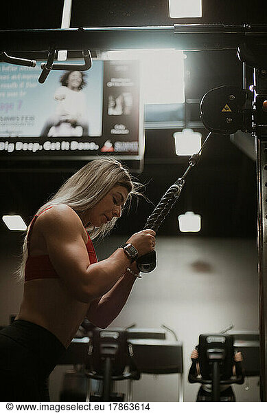 Blonde woman working out in gym with sun coming through window