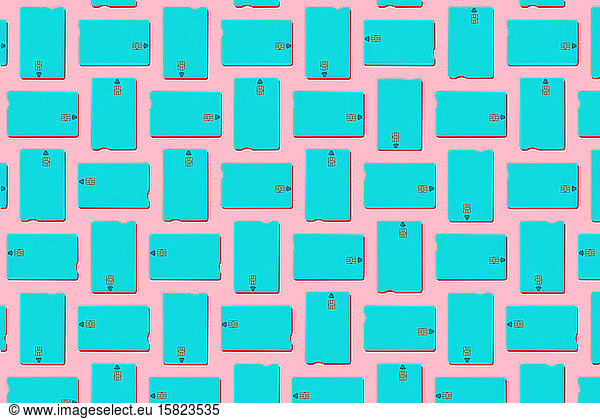 Blue contactless credit cards pattern on pastel pink background