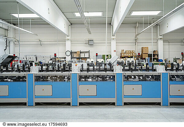 Blue machinery at illuminated production hall