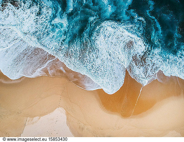 Blue ocean waves aerial drone shot on sandy beach