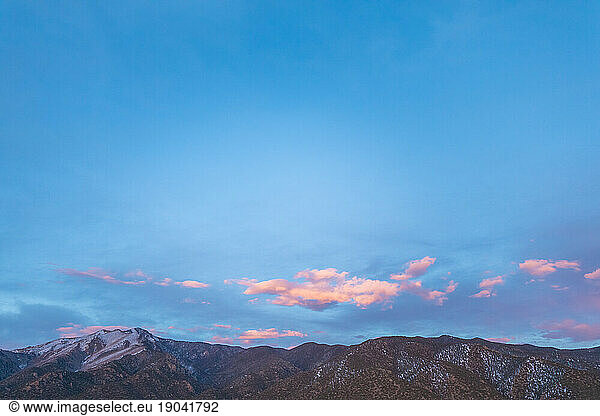 blue sky and pink clouds after spring sunset in colorado foothills