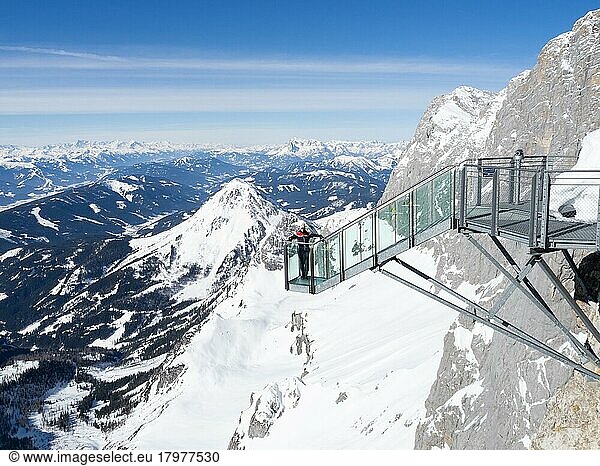 Blue sky over alpine winter landscape  tourist standing on the stairs to nowhere  snow-covered alpine peaks  Dachstein massif  Styria  Austria  Europe