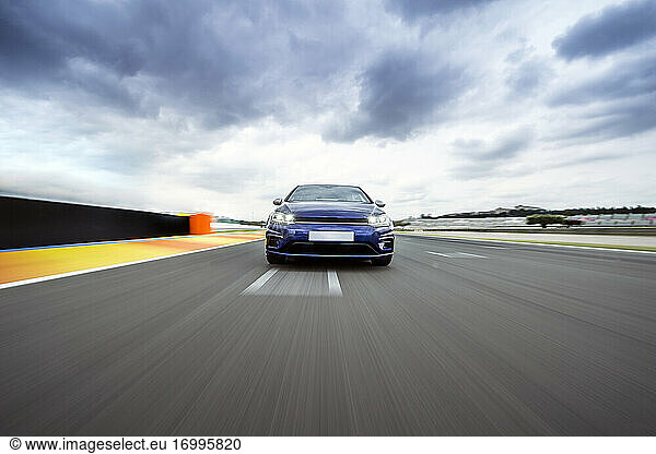 Blue sports car racing on asphalt track