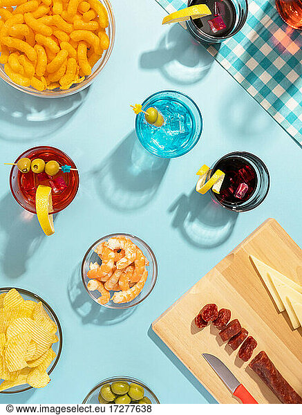 Blue table set with various snacks  appetizers and cocktails