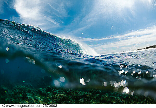 Blue wave crashing over coral reef