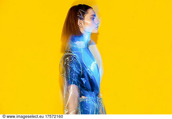 blue  yellow mixed-light fashion portrait of futuristic style woman