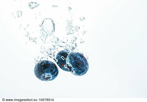Blueberries splashing in water isolated on white background. Product photography  antioxidant concept.