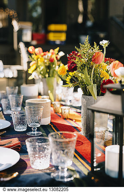 Blumenvasen nach Trinkgläsern auf dem Tisch arrangiert
