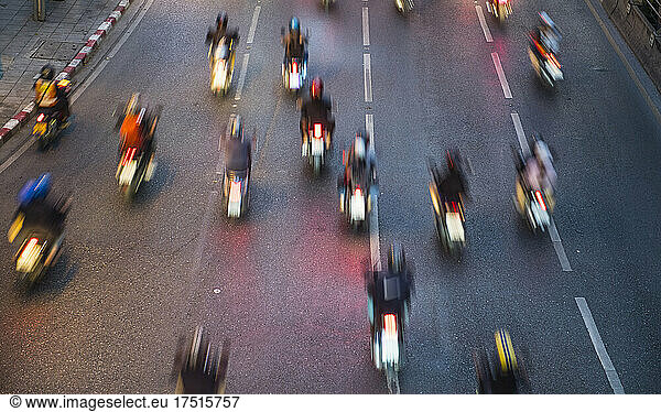 blurred image of motorcycles on a road in Bangkok
