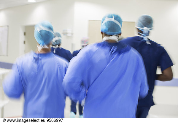 Blurred motion of surgeons walking towards hospital