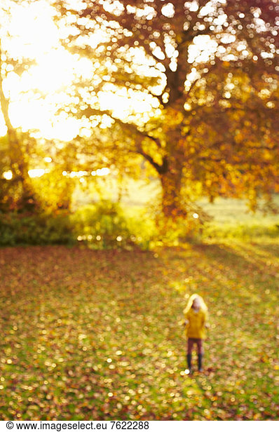 Blurred view of girl standing in meadow
