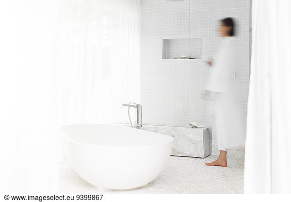 Blurred view of woman walking in modern bathroom