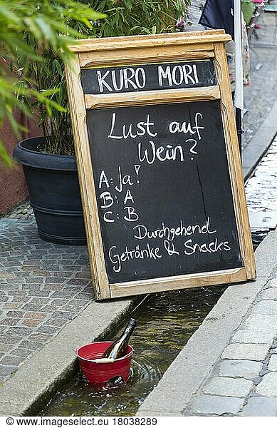 Board with inscription Lust auf Wein? in front of a restaurant  in the foreground a wine bottle in a bucket for cooling in the Bächle  Freiburg im Breisgau  Baden-Württemberg  Germany  Europe