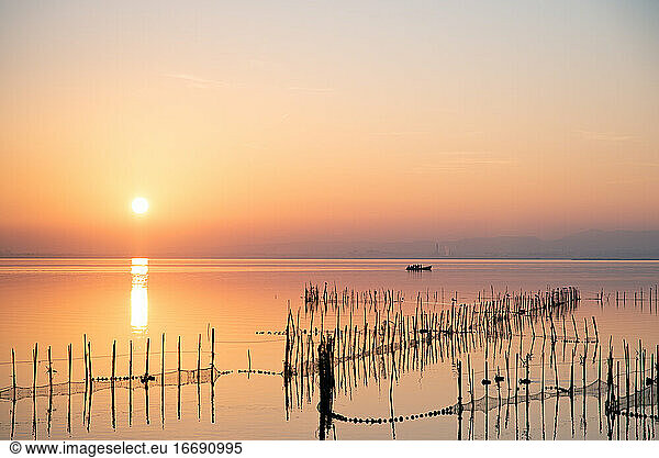 Boat and fishing nets at Valencia's Albufera sunset against the light