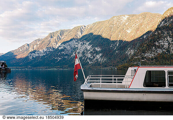 boat with an Austrian flag near the shores of Lake Hallstatt