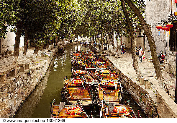 Boats in canal amidst buildings