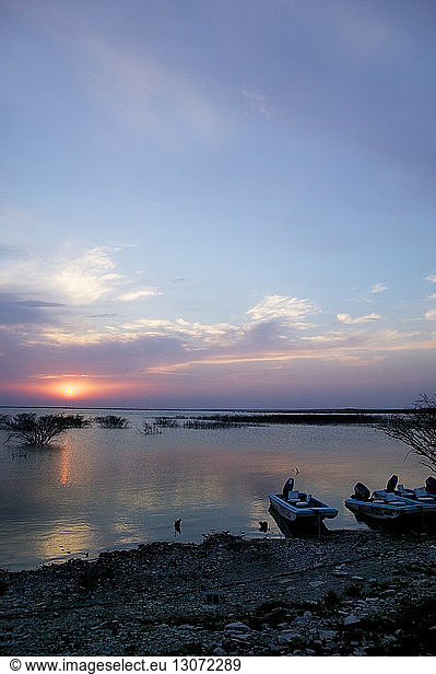 Boats mood at shore during sunset