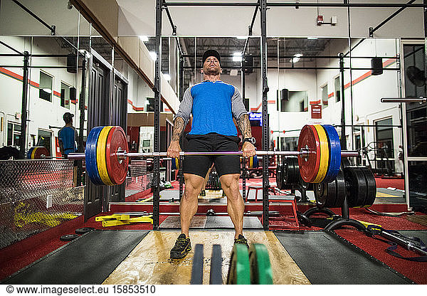bodybuilder completes deadlift in the gym.