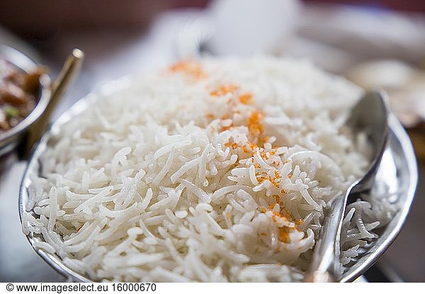 Boiled basmati rice on metal tray in Indian restaurant.