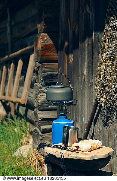 Boiling water in hiking kettle. Outdoor cooking equipment  mugs  kettle and portative stove