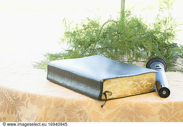 Book and microphone on table with floral arrangement.