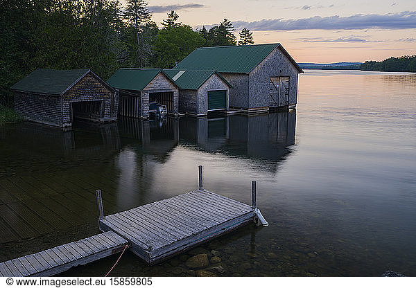 Bootshäuser bei Sonnenuntergang auf einem See in Maine