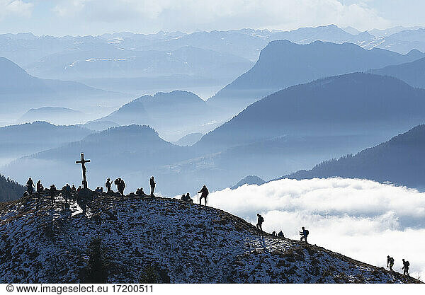 Border region Austria Germany  Heuberg  Silhouettes of backpackers hiking to mountain peak