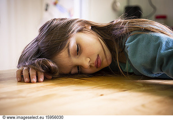 Bored girl lying on kitchen table