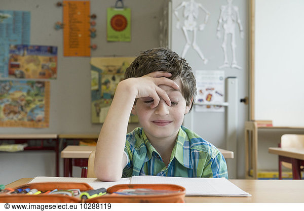 Bored schoolboy in classroom  Munich  Bavaria  Germany