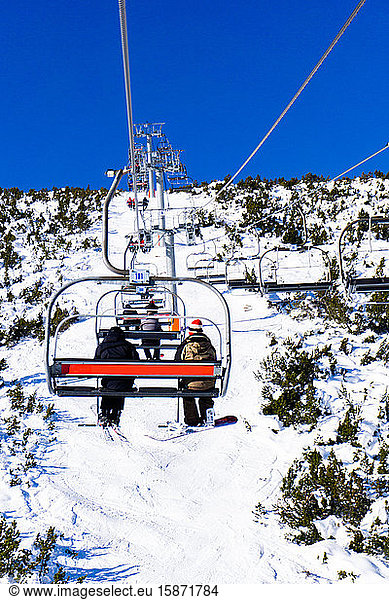 Borovets Ski Resort  a skier and snowboarder sit on Markudjik ski lift  Bulgaria  Europe