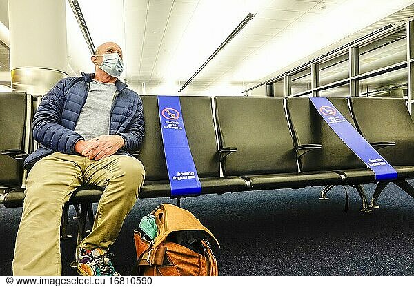 Boston Massachusetts  USA Ein Mann sitzt im Abflugterminal des Logan-Flughafens mit sozialen Distanzbändern  die den Kontakt verhindern sollen.