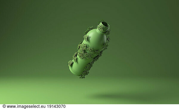 Bottle covered with green plants against green background