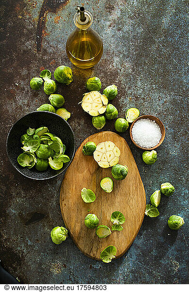 Bottle of olive oil and halved Brussels sprouts on cutting board