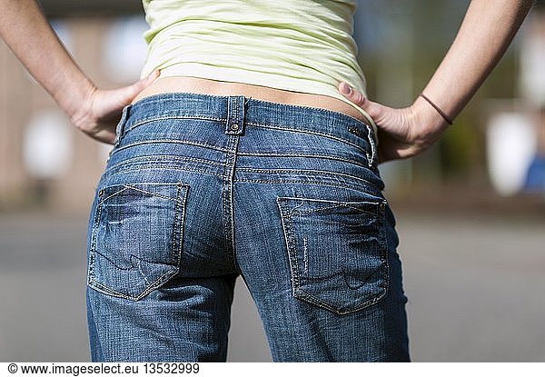 Bottom of a young woman in jeans
