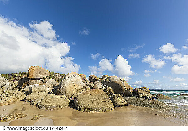 Boulders on sandy coastal beach in summer Australia
