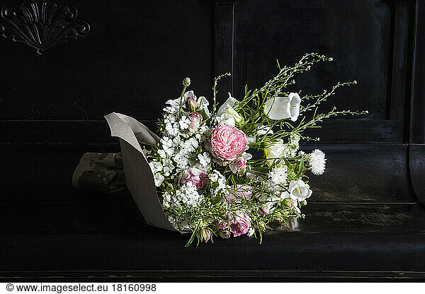 Bouquet of various freshly cut flowers lying on top of piano