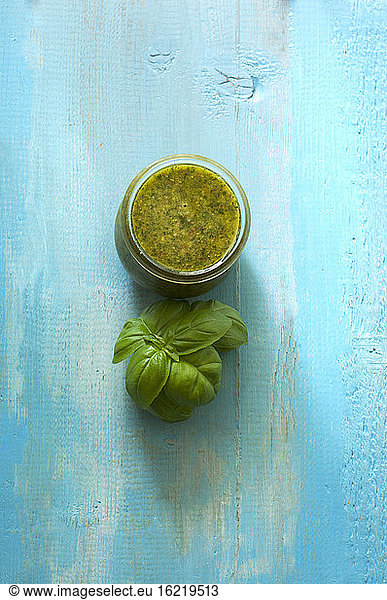 Bowl of basil pesto on wooden table  close up