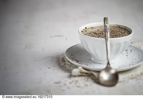 Bowl of coffee sprinkled with chocolate  close up