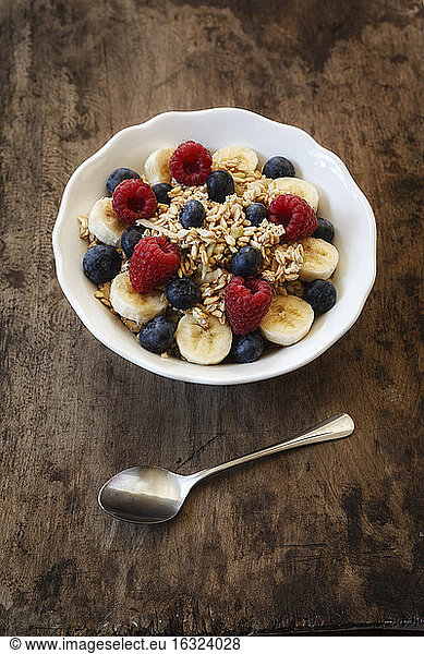 Bowl of muesli with banana slices  raspberries and blueberries