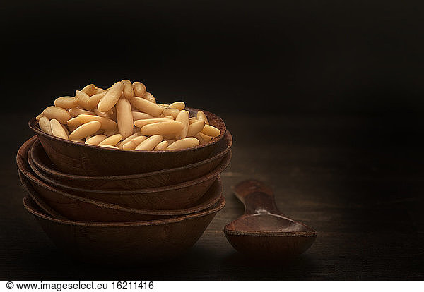 Bowl of pine nuts with wooden spoon  close up