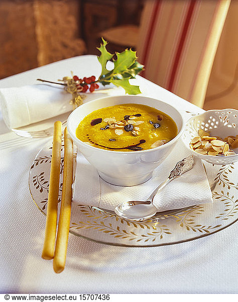 Bowl of pumpkin soup with ginger and orange juice