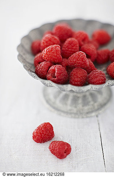 Bowl of raspberries on wooden table  close up