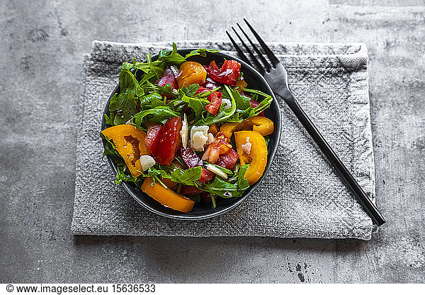 Bowl of salad with red and yellow tomatoes  arugula and Parmesan