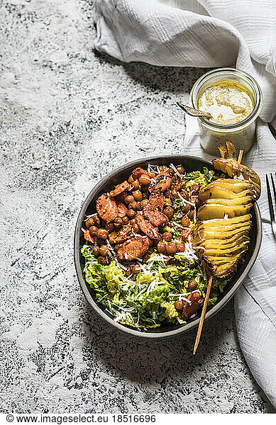 Bowl of salad with roasted chickpeas  carrots and roasted potato on skewer