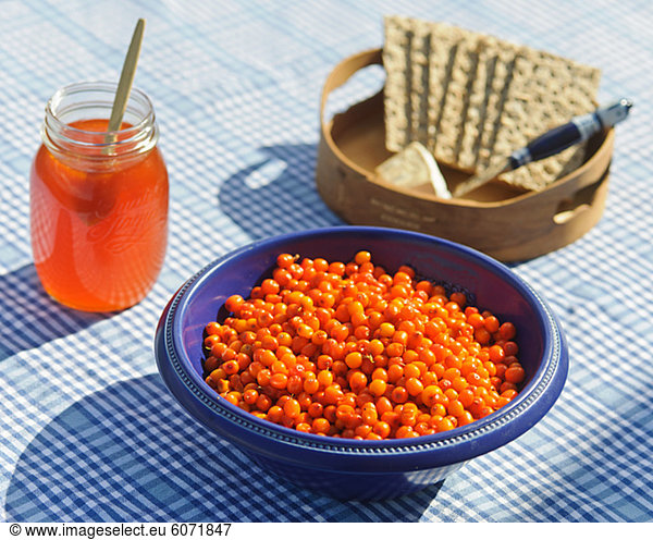 Bowl of sea buckthorn berries  crisp bread and marmalade