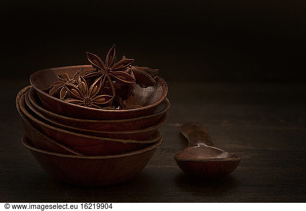 Bowl of star anise with wooden spoon  close up